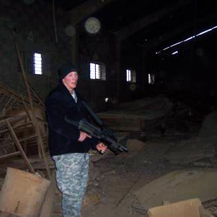 Jason Matheny holds a gun in Iraq.