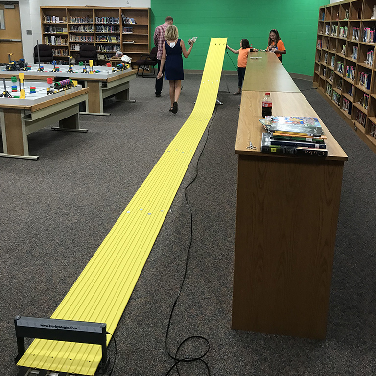 A long, yellow track sits in a school library.