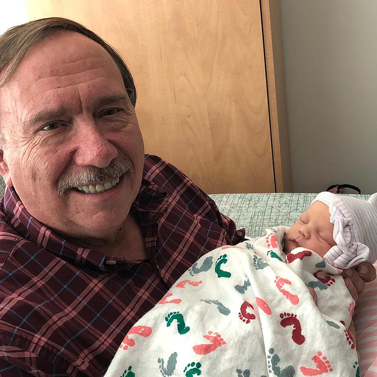 Ronald Pevey holds his newborn granddaughter.