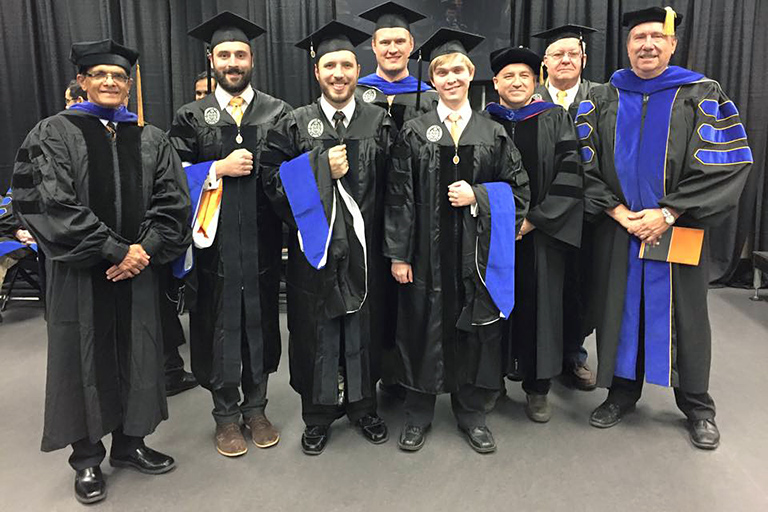 Ronald Pevey and a group of faculty and students at the 2016 hooding ceremony.