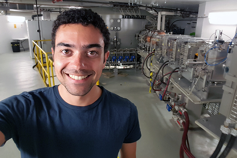 Micah Folsom in front of an accelerator.