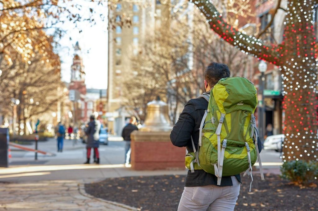 A student walks through Market Square wearing a green backpack that contains the radiation detector.
