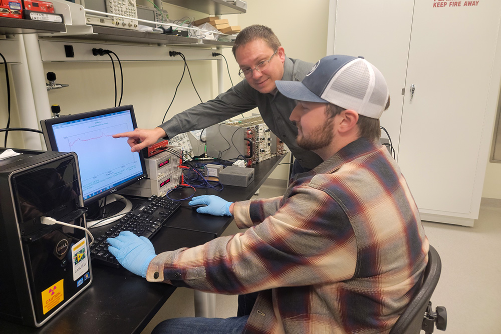 Eric Lukosi and graduate student Heath Davis working in the lab.