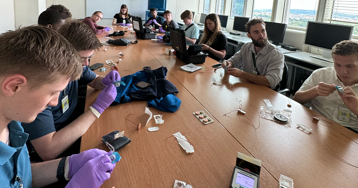 study abroad students getting in person demonstrations of seals and dectectors used at International Atomic Energy Agency