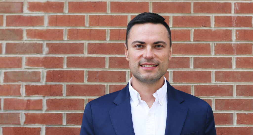 Alex Ivanov standing in front of a brick building