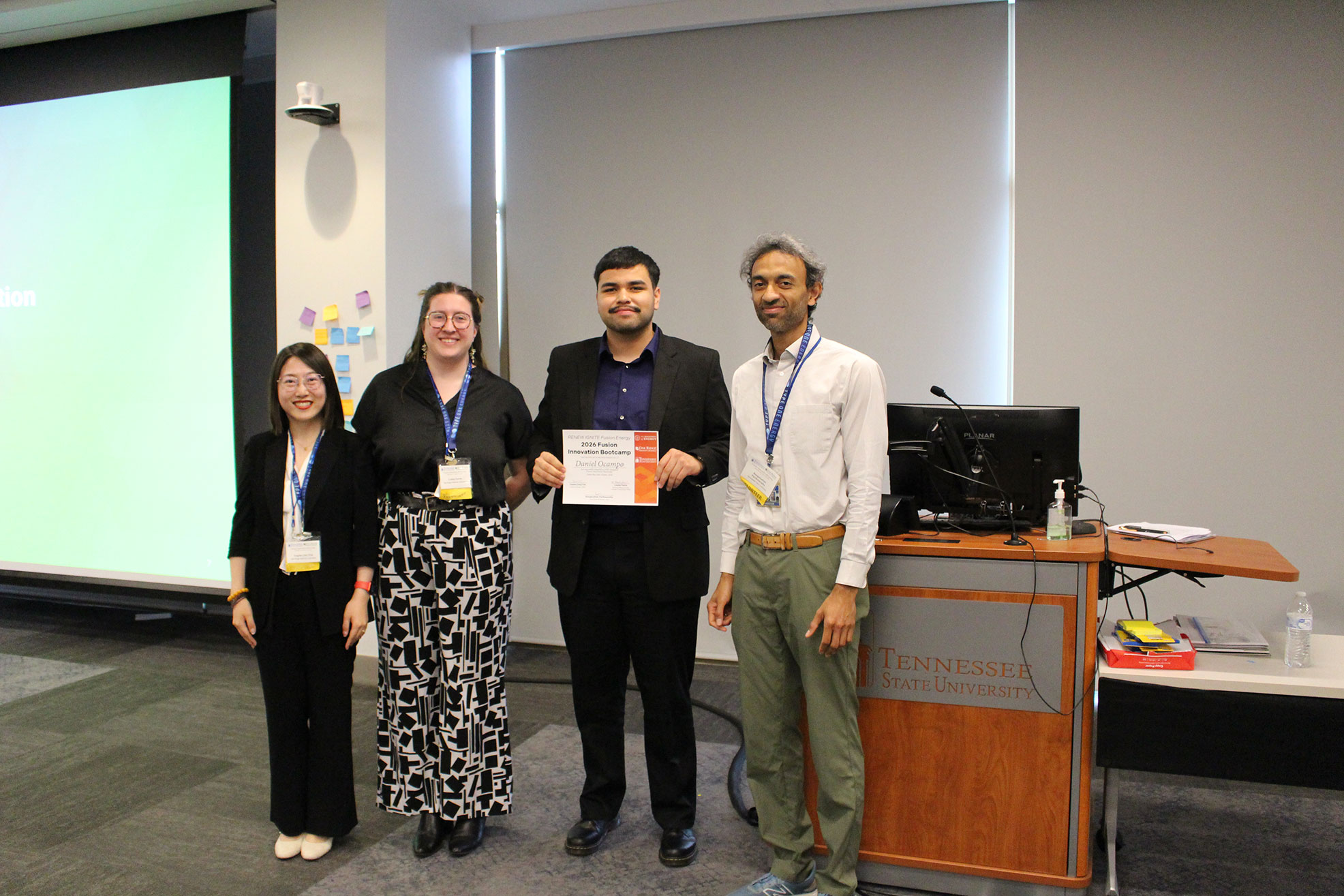 Daniel Ocampo holding a certificate while standing with other TCE students 